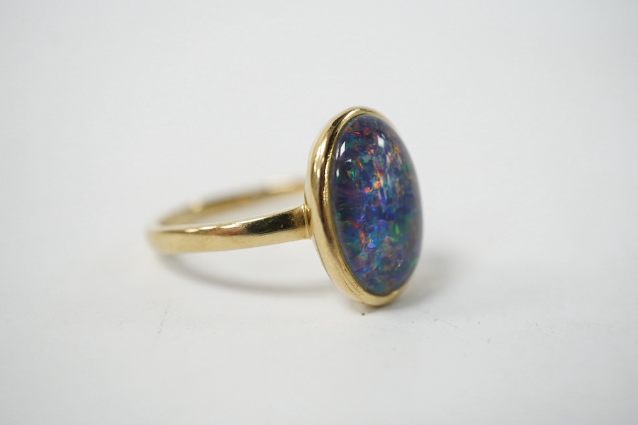 A modern 9ct gold and oval opal triplet set ring, size P/Q, gross weight 4 grams. Condition - good